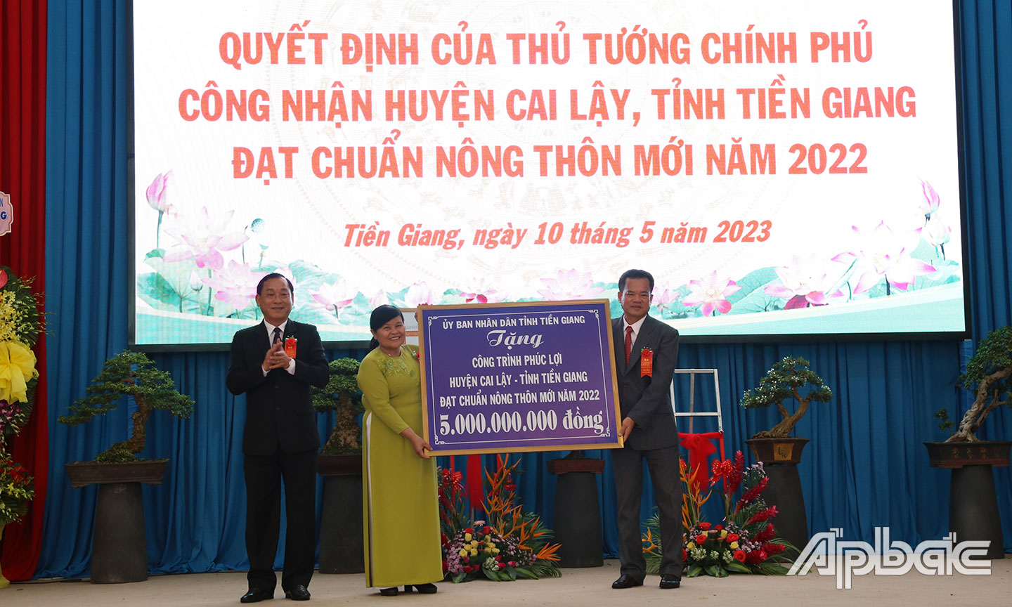 Đồng chí Nguyễn Văn Vĩnh trao bảng tượng trưng công trình phúc lợi cho Đảng bộ, Chính quyền và Nhân dân huyện Cai Lậy