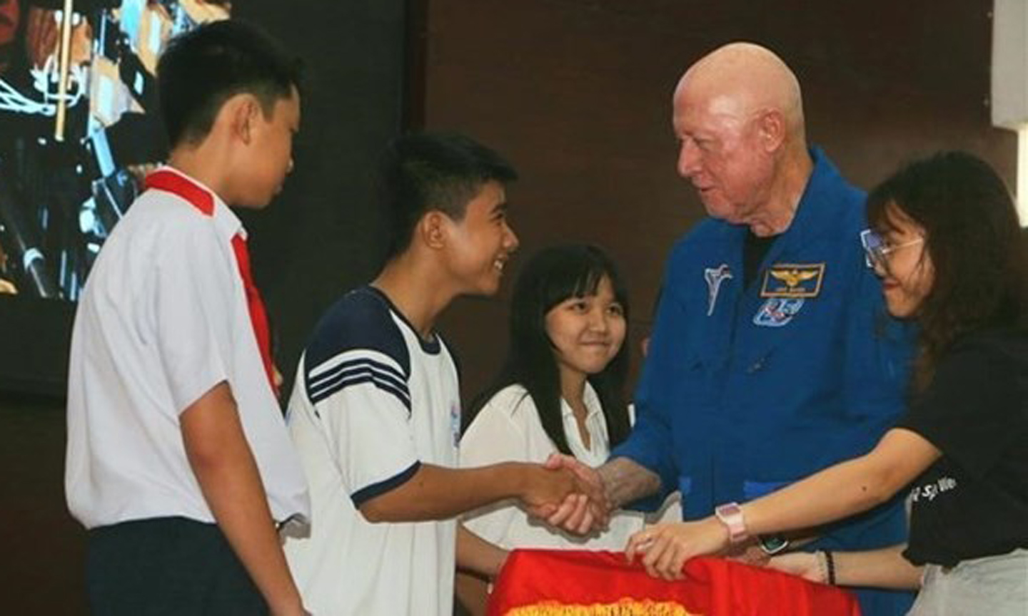 Astronaut Michael Baker and local students at the event. (Photo: VNA).