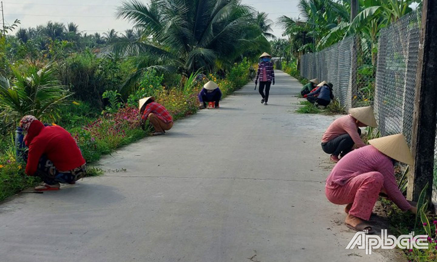 Cán bộ, hội viên, phụ nữ xã Điềm Hy chăm sóc tuyến đường hoa làm đẹp  cảnh quan môi trường.