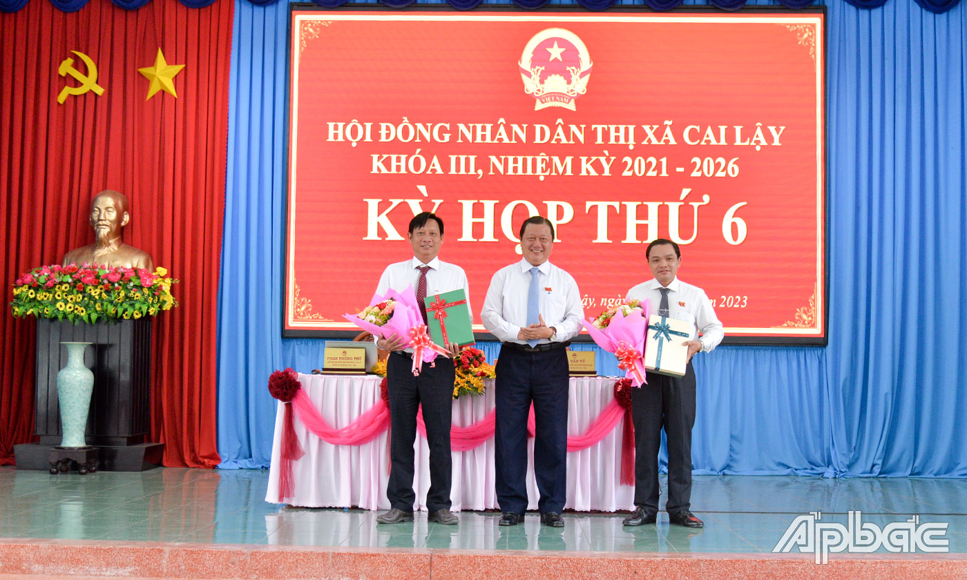 Đồng chí Phan Phùng Phú tặng hoa và quà miễn nhiệm 2 Ủy viên UBND TX. Cai Lậy khóa III, nhiệm kỳ 2021 - 2026 đối với đồng chí Phạm Văn Vạn và đồng chí Trần Mạnh Khương.