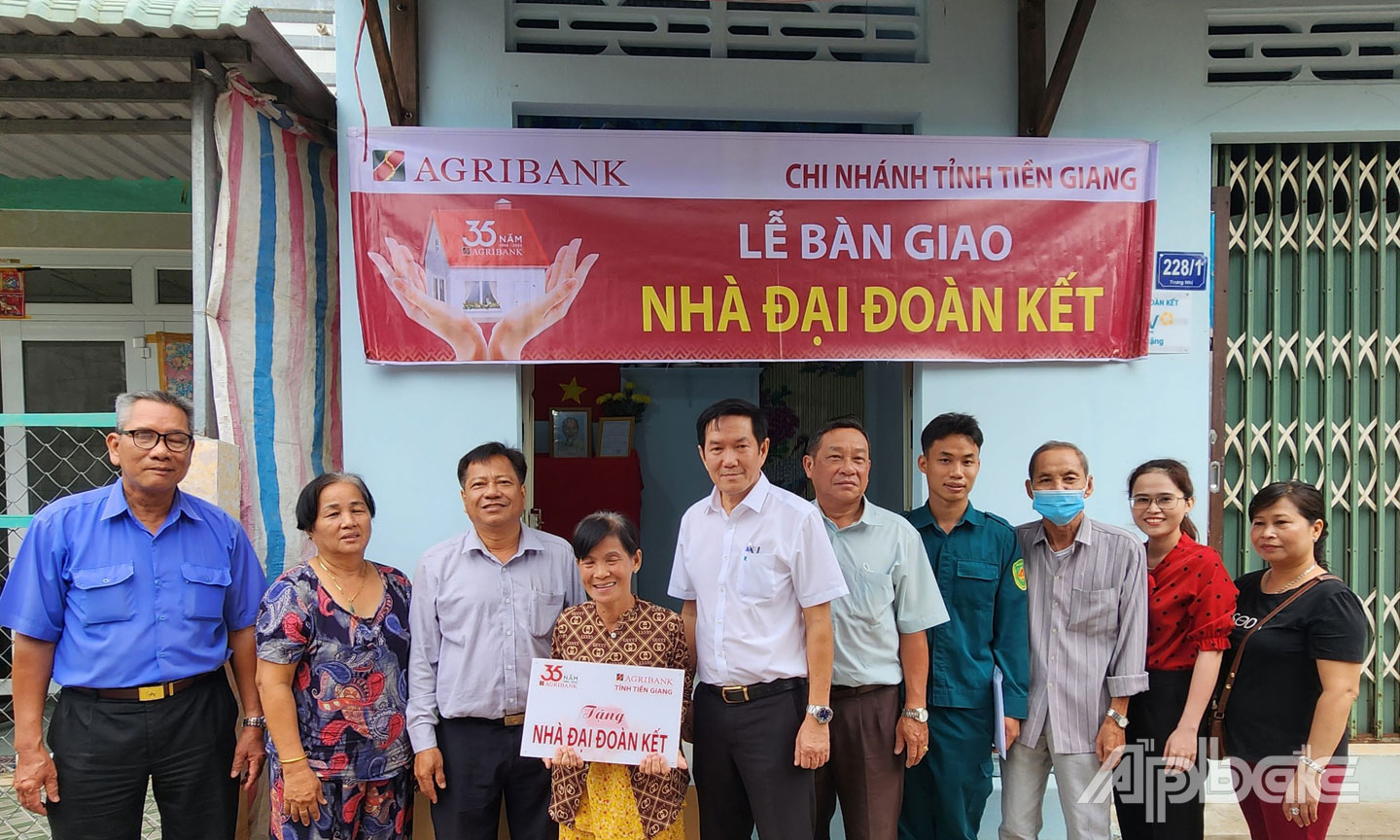 Phó Giám đốc, Chủ tịch Công đoàn cơ sở Agribank Tiền Giang Trương Văn Đoàn (thứ 5 từ trái) cùng chính quyền địa phương bàn giao nhà cho bà Nguyễn Thị Nương.