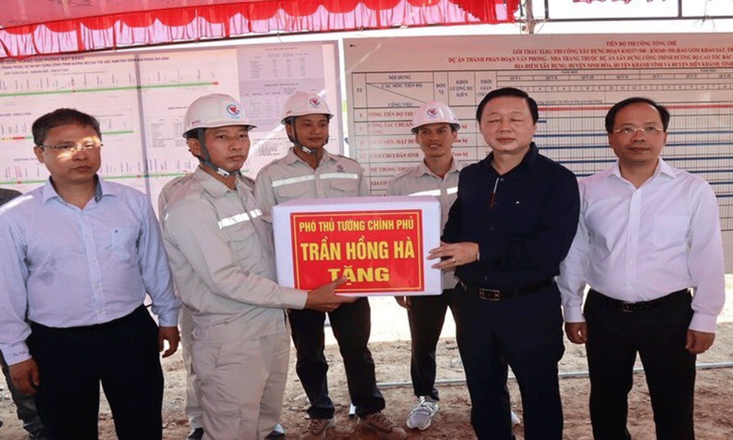 Deputy PM Tran Hong Ha presents gifts to workers and engineers at the construction site.