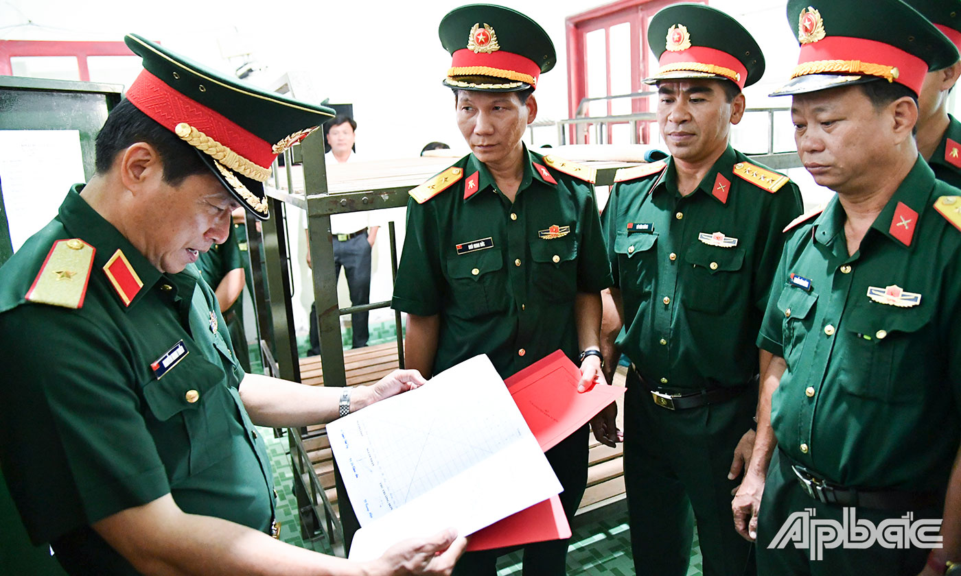 Thiếu tướng Nguyễn Minh Triều, Phó Tư lệnh Quân khu 9 kiểm tra sổ bàn giao vũ khí trang bị tại Ban CHQS xã Phú Tân (huyện Tân Phú Đông).