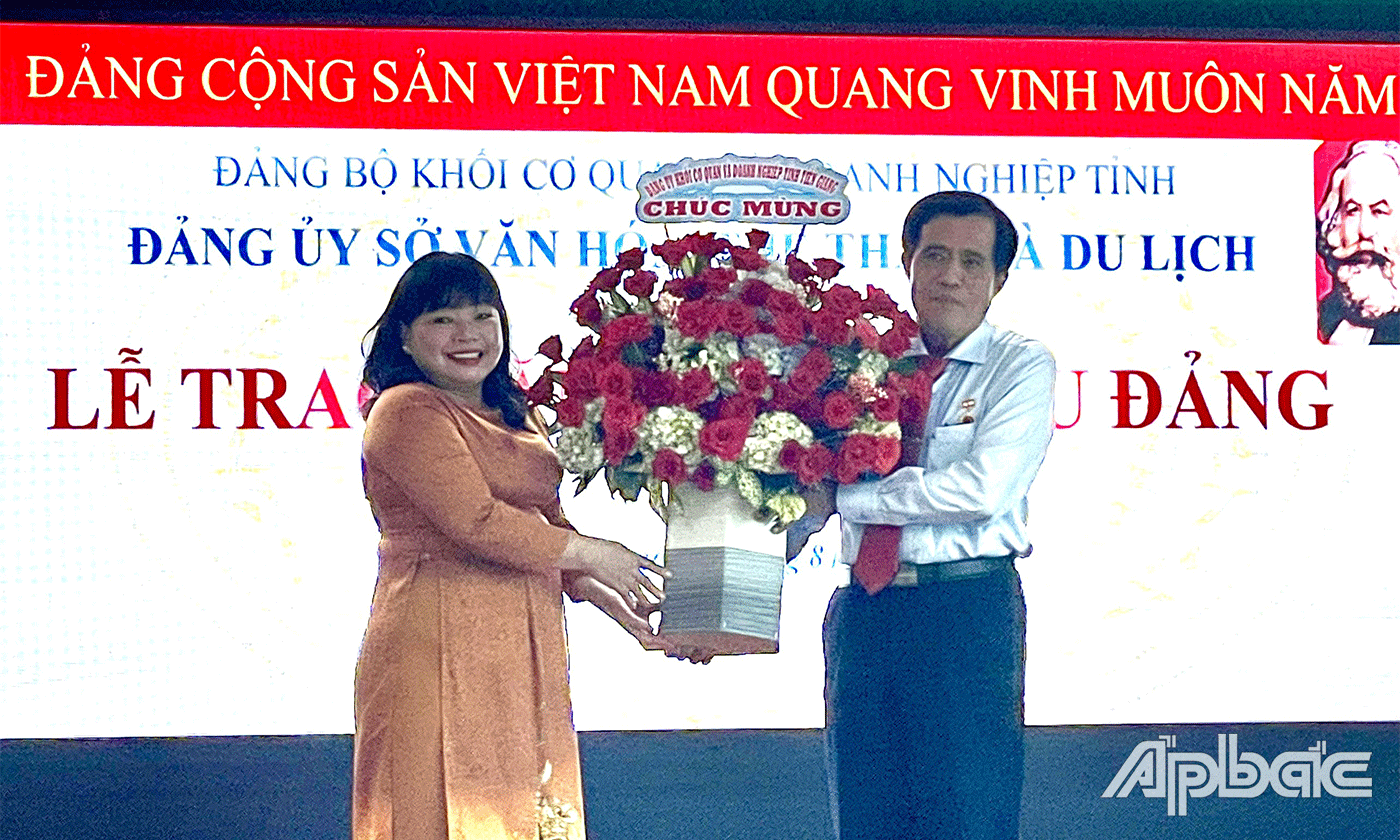 Bí thư Đảng uỷ Khối cơ quan và doanh nghiệp tỉnh Thái Ngọc Bảo Trâm tặng hoa chúc mừng đồng chí Nguyễn Đức Đảm.