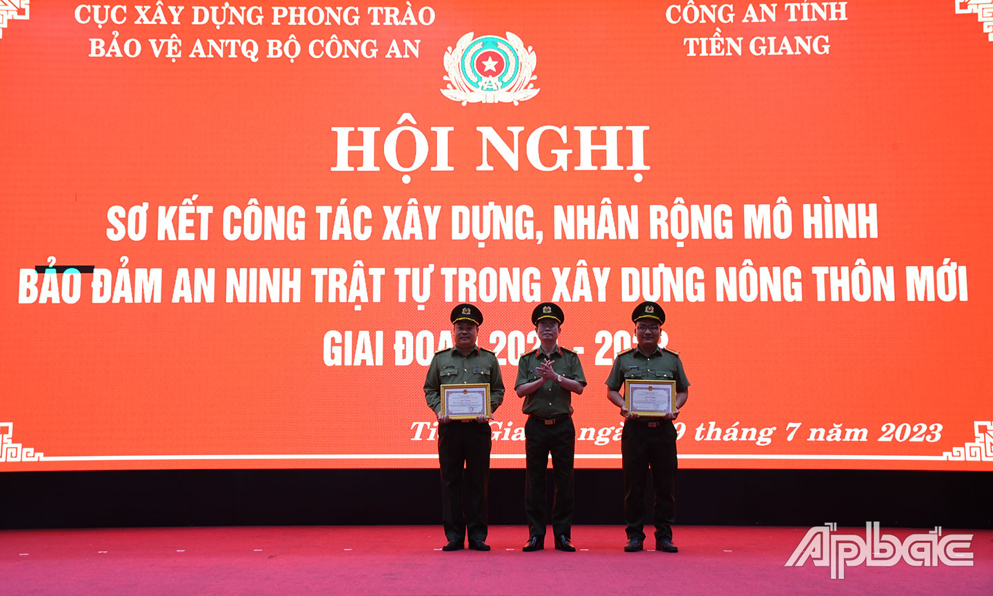 Đại tá Nguyễn Thế Chi, Phó Cục trưởng Cục Xây dựng phong trào BVANTQ trao Bằng khen của Bộ Công an tặng  tập thể và cá nhân đạt thành tích tốt trong tham gia xây dựng mô hình “Đảm bảo ANTT trên địa bàn xã Mỹ Phong,  TP. Mỹ Tho năm 2022”. 								                Ảnh: Lê Hoài