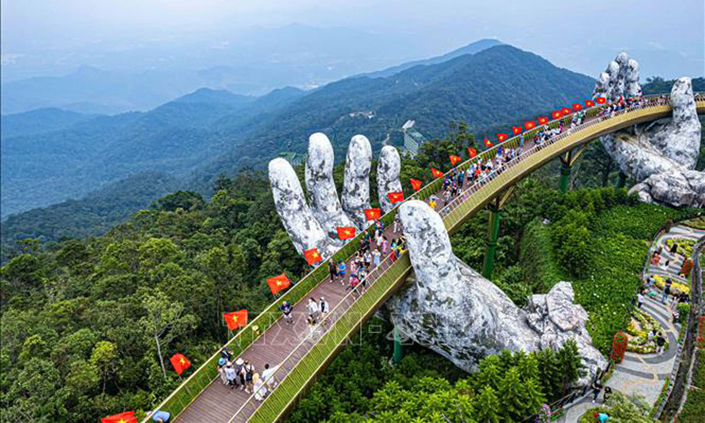 Đón lễ Quốc khánh năm nay, Khu du lịch Sun World Ba Na Hills trang trí 100 lá cờ đỏ, sao vàng dọc thành Cầu Vàng với tổng chiều dài 148,6m. Ảnh: TTXVN phát