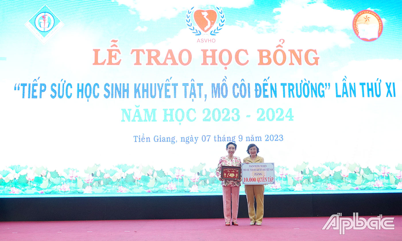 PGS.TS. Nhà giáo Ưu tú Trương Thị Hiền, Phó Chủ tịch Hội Khuyến học Việt Nam trao bảng tượng trưng 1.000 quyển tập cho các em khuyết tật, mồ côi