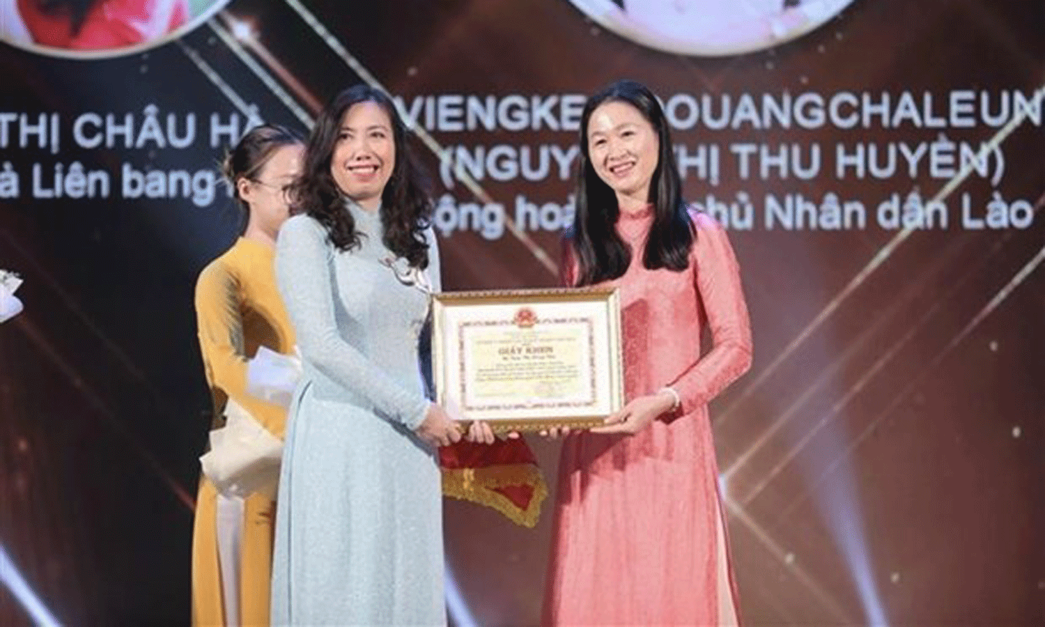 Deputy Minister of Foreign Affairs Le Thi Thu Hang (left) gives a certificate of merit to a candidate who won the title 