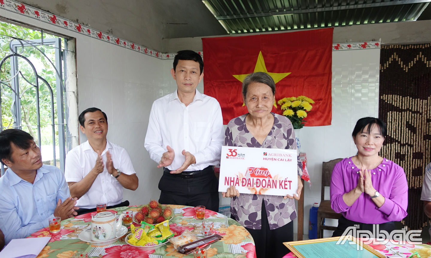 Ông Trần Duy Tuân, Phó Giám đốc Agribank tỉnh Tiền Giang trao bảng tượng trưng nhà đoàn kết cho hộ nghèo tại xã Hiệp Đức.