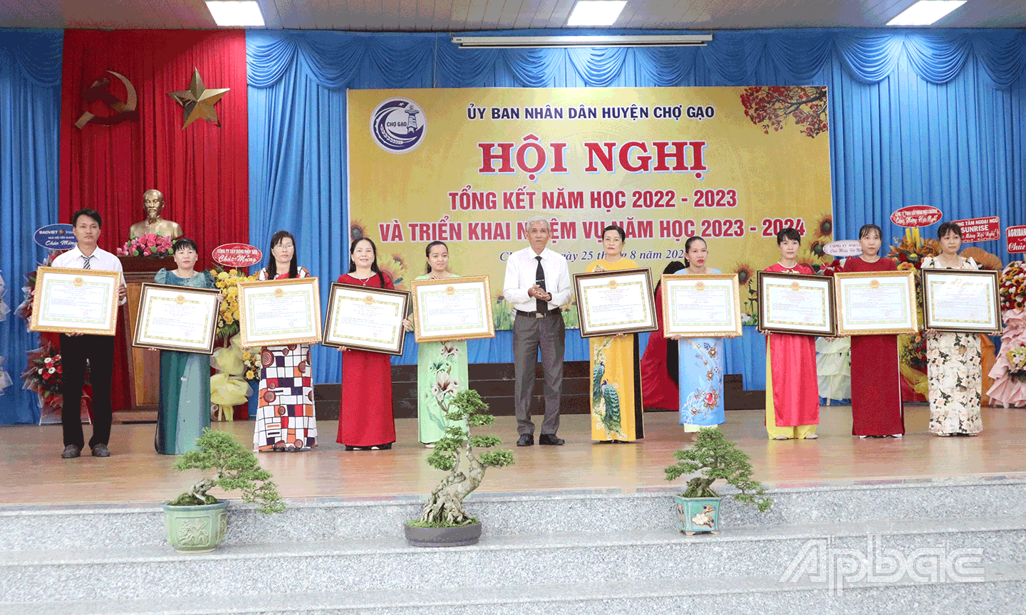 Cô Nguyễn Thị Thật, Hiệu trưởng Trường Tiểu học Quơn Long (thứ 2 từ trái qua) nhận Bằng khen của UBND tỉnh.