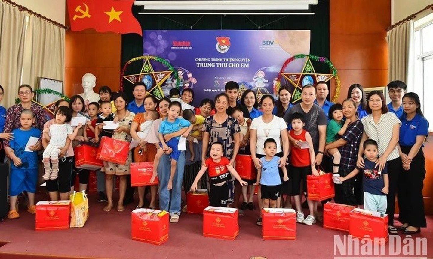 Members of the Youth Union of Nhan Dan Newspaper present gifts to disadvantaged children in Thanh Xuan District, Hanoi. (Photo: NDO/Thuy Nguyen).