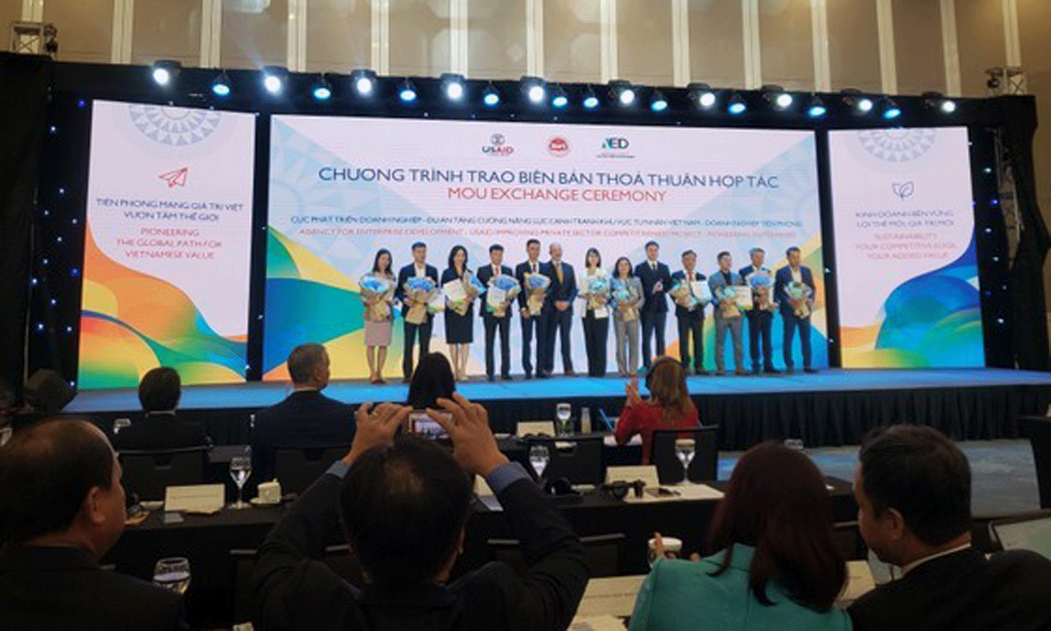 The Ministry of Planning and Investment (MPI) and US Agency for International Development (USAID) hand over cooperation pacts to the first 22 Vietnamese pioneering enterprises (PEs) at the forum. (Photo: kinhtevadubao.vn)