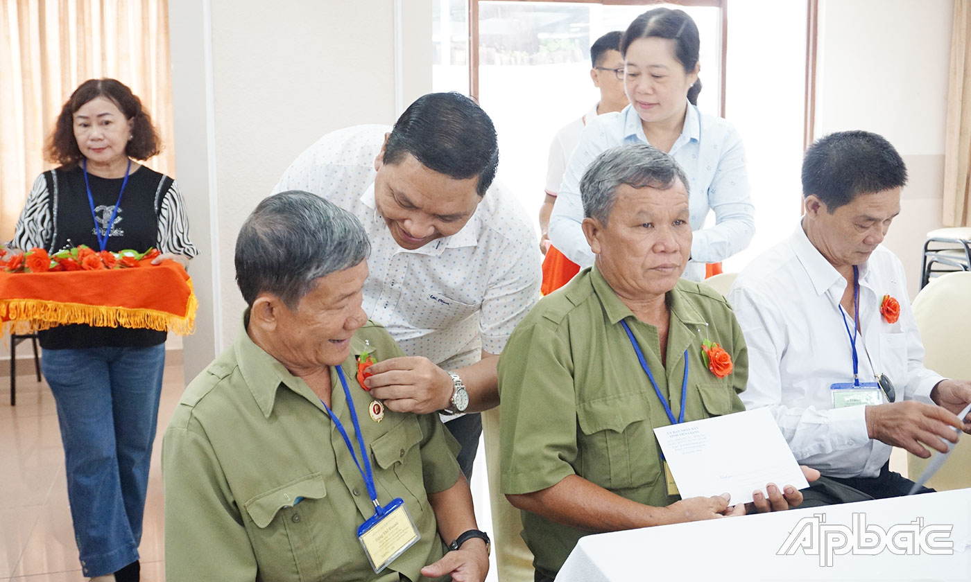 Giám đốc Sở Lao động Thương binh và Xã hội tỉnh Lý Văn Cẩm cài hoa và tặng quà cho người có công với cách mạng