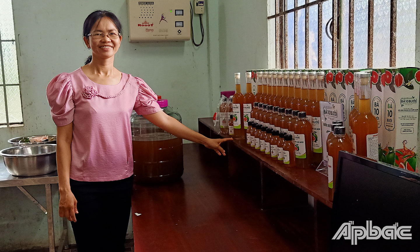 Chị Lê Thị Minh Tâm bên sản phẩm nước bưởi lên men và rượu bưởi da xanh.