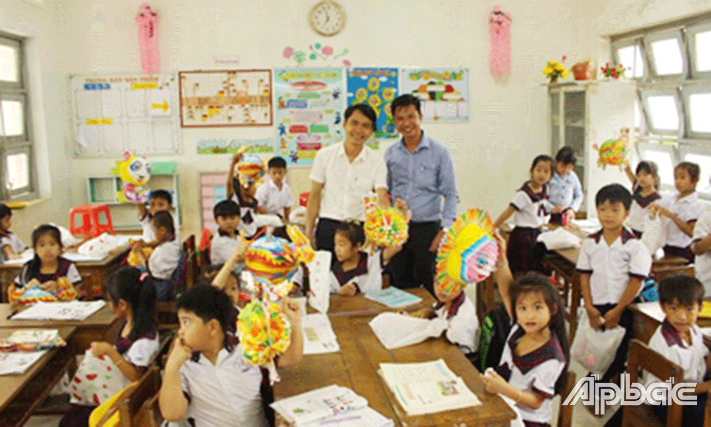 Anh Trần Minh Thanh (người đứng bên phải) trong 1 lần tặng quà nhân dịp Tết Trung thu cho trẻ em nghèo ở huyện Tân Phú Đông.
