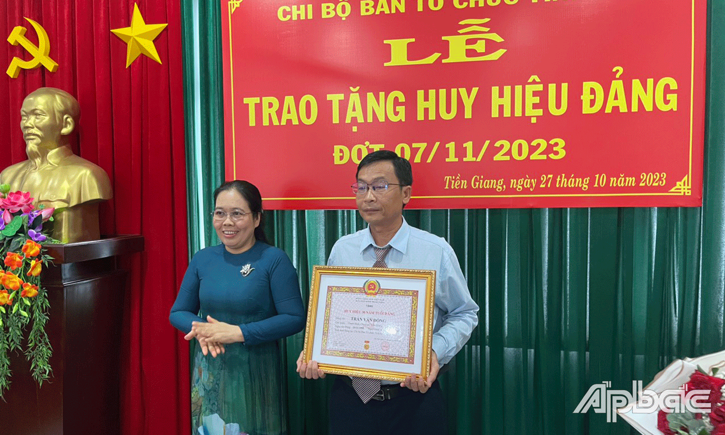 Đồng chí Nguyễn Thị Lan, TUV - Bí thư Chi bộ Ban Tổ chức Tỉnh uỷ trao Huy hiệu Đảng 30 năm cho đảng viên Trần Văn Đồng