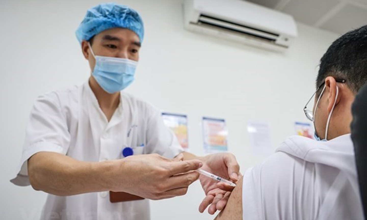 A health staff injects a dose of COVID-19 vaccination for a man. (Photo: VNA).