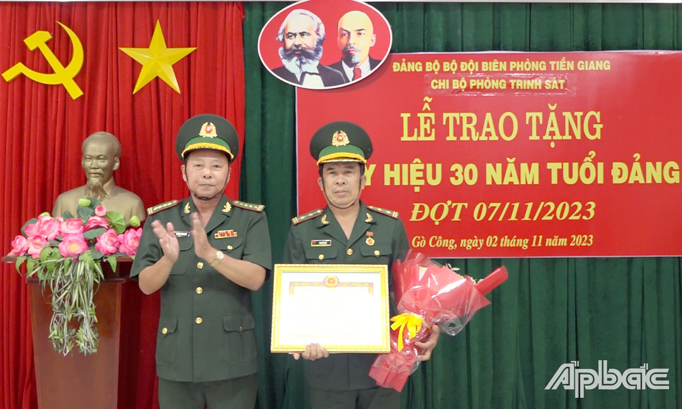 Đại tá Trương Công Sâu, Ủy viên Ban Thường vụ Đảng ủy BĐBP tỉnh trao quyết định và gắn Huy hiệu 30 năm tuổi Đảng cho Trung tá chuyên nghiệp Phan Hữu Đạt. 