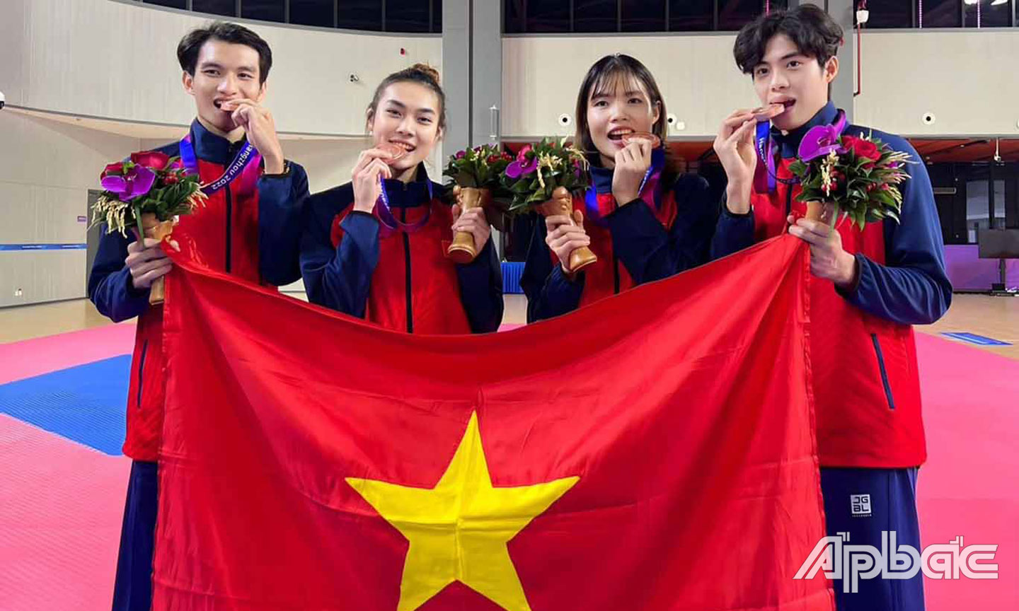 VĐV Phạm Minh Bảo Kha (bìa phải) cùng với các đồng đội đoạt HCĐ ở nội dung đồng đội bộ môn Taekwondo tại ASIAD 19.