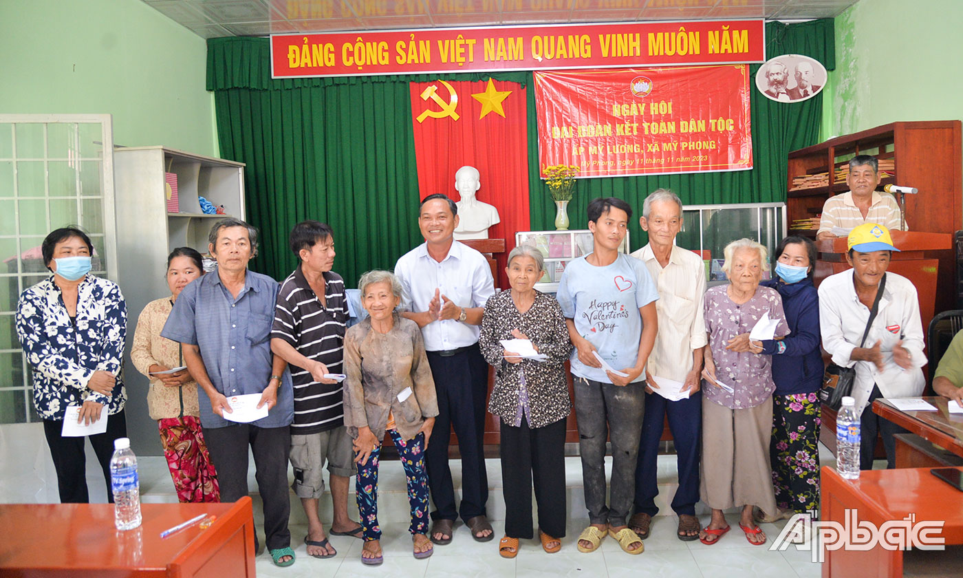 Đại tá Phạm Văn Thanh trao quà của Ban Vận động Quỹ vì người nghèo tỉnh Tiền Giang cho các hộ nghèo, hộ cận nghèo.