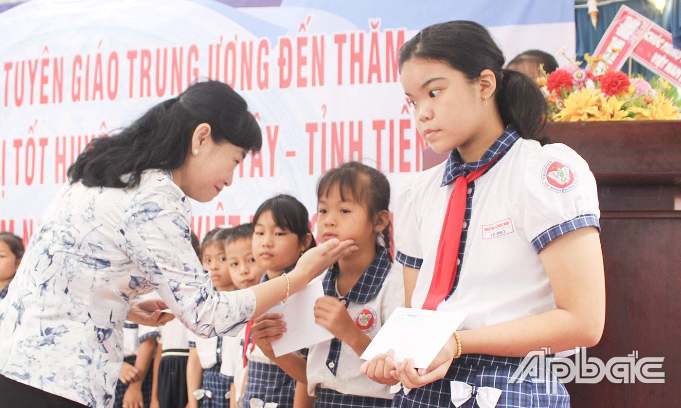 Trưởng Ban Tuyên giáo Tỉnh ủy Châu Thị Mỹ Phương trao quà cho các em học sinh trường THCS Xuân Diệu. 