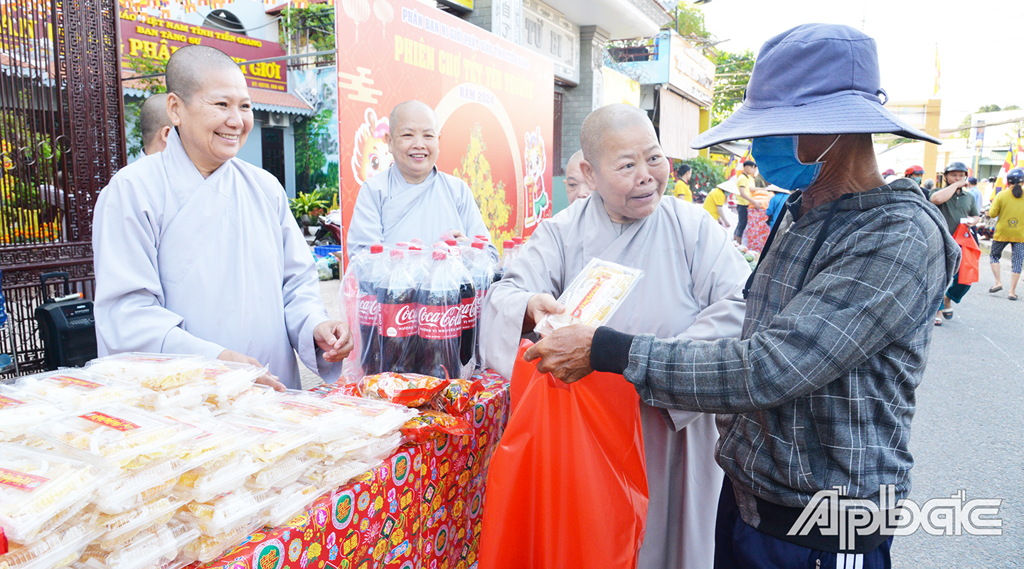 Ni trưởng Thích nữ Tĩnh Nghiêm, Phó Ban Trị sự Phật giáo tỉnh, Trưởng phân ban ni giới trao hàng cho người dân đến phiên chợ