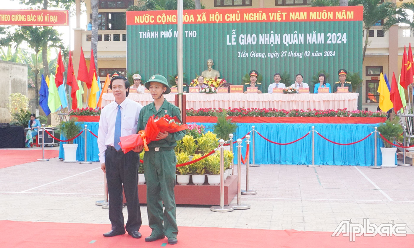 Đồng chí Nguyễn Văn Danh tặng hoa cho tân binh Lê Nguyễn Duy Nam đại diện 169 thanh niên TP. Mỹ Tho lên đường nhập ngũ.