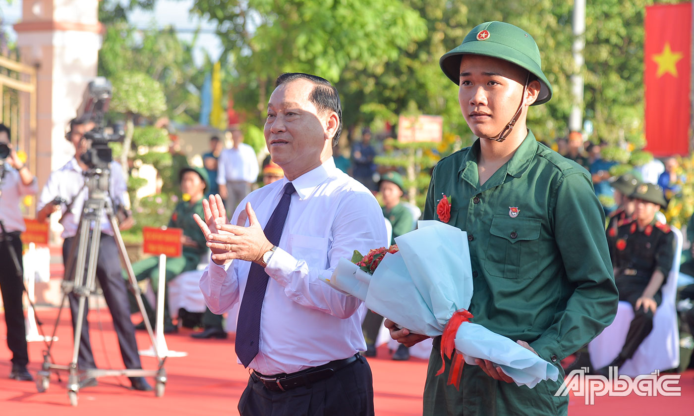 Đồng chí Nguyễn Văn Vĩnh tặng hoa cho tân binh Huỳnh Quang Hòa đại diện 171 thanh niên huyện Gò Công Tây lên đường nhập ngũ.