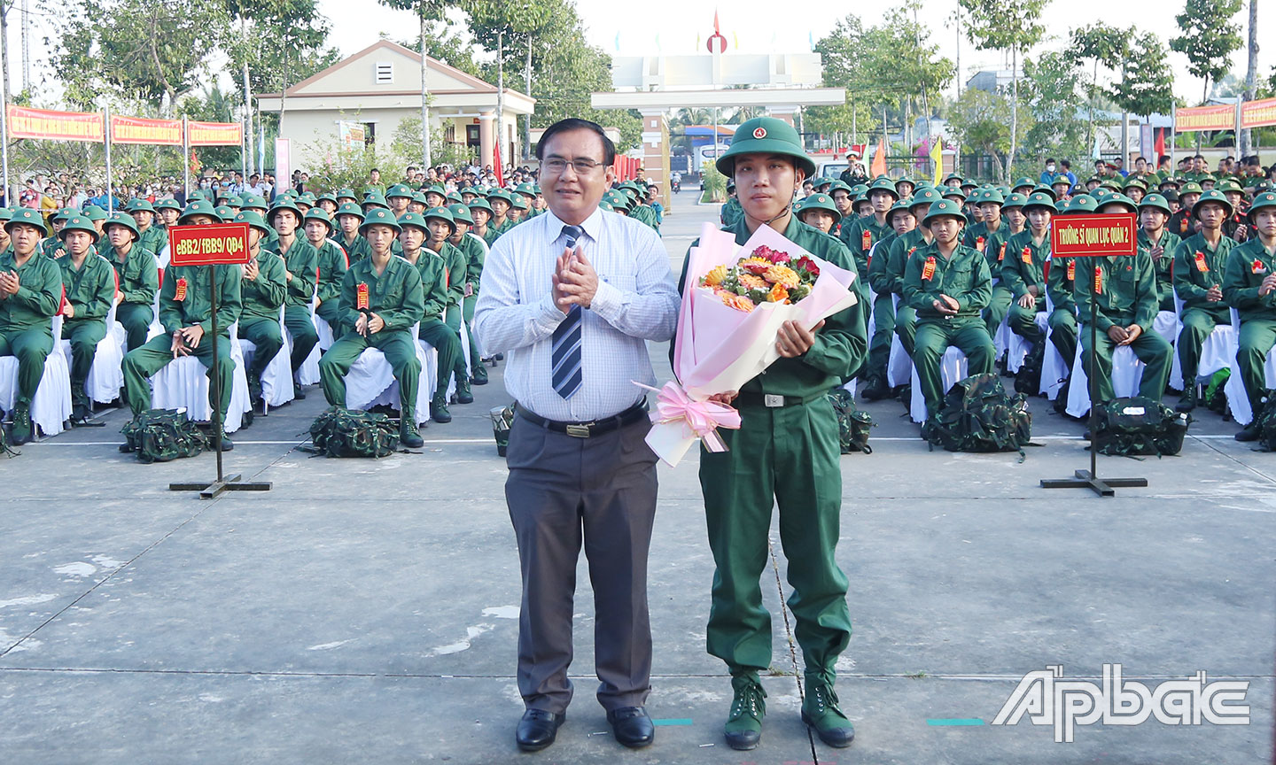 Đồng chí Võ Văn Bình tặng hoa đại diện tân binh phát biểu tại buổi lễ.