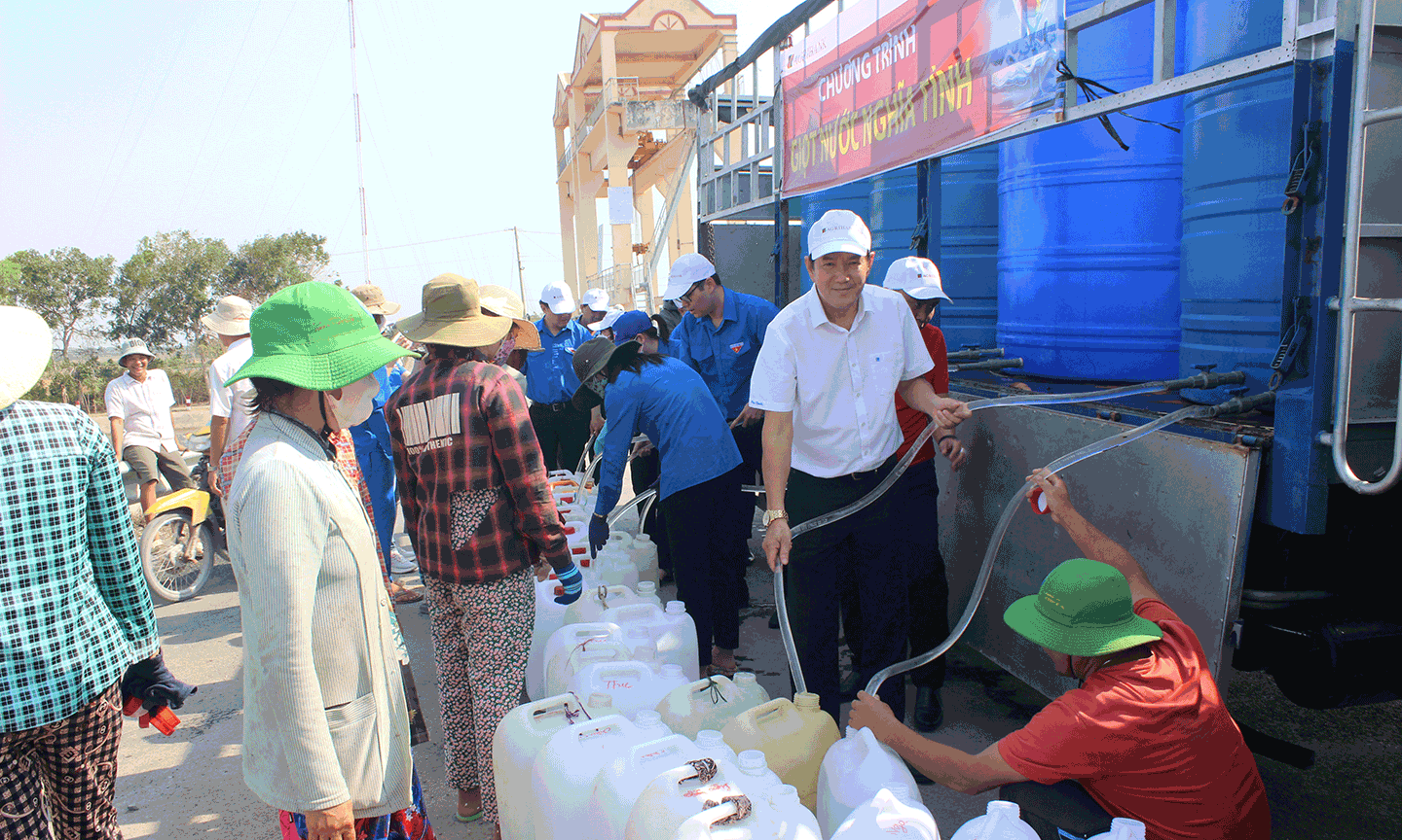 Phó Giám đốc, Chủ tịch Công đoàn cơ sở Agribank Tiền Giang Trương Văn Đoàn (áo trắng) trực tiếp đến trao nước và động viên, sẻ chia khó khăn thiếu nước của bà con.