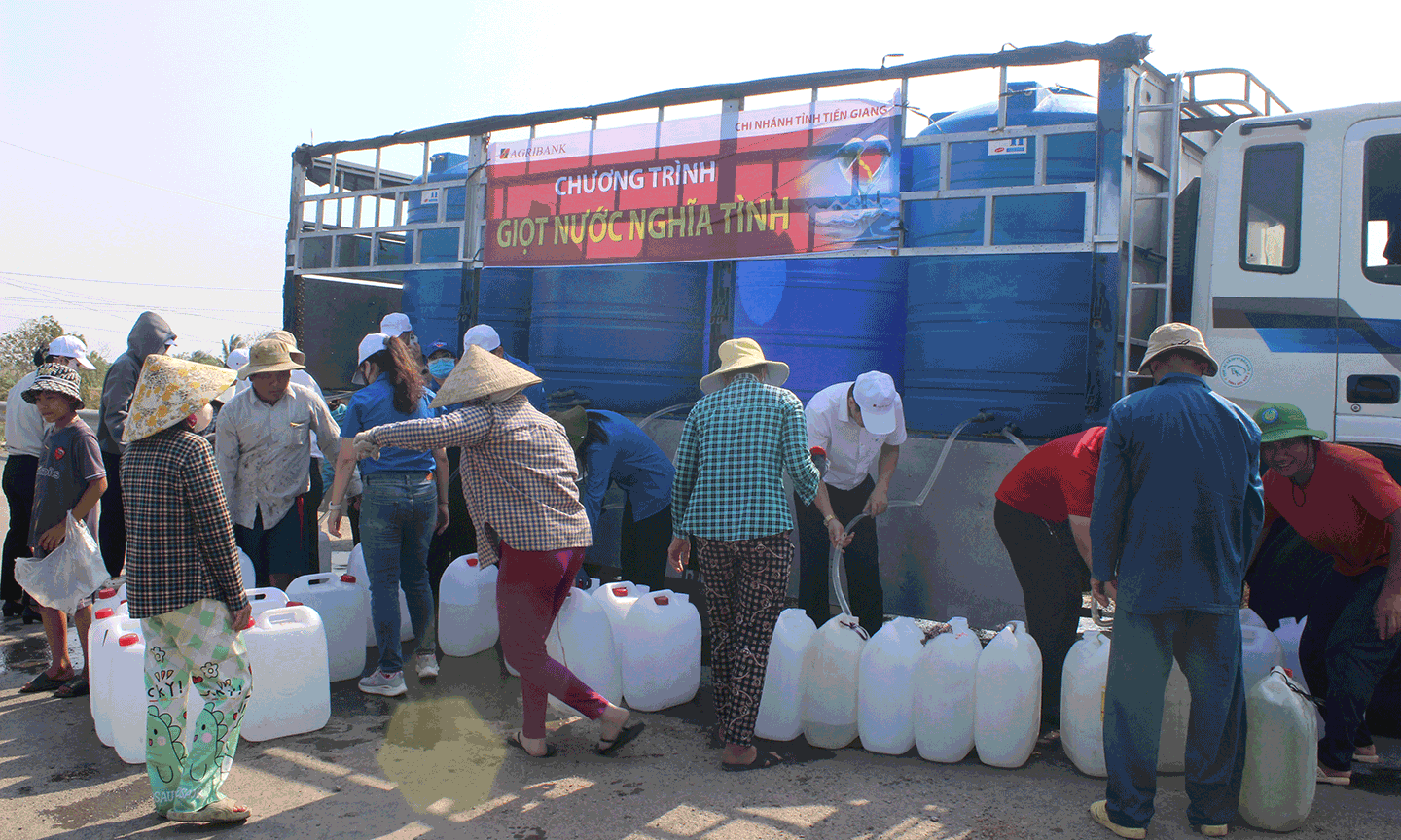 Bà con xã Tân Điền, huyện Gò Công Đông vui mừng nhận nước sạch dùng trong sinh hoạt do Agribank Tiền Giang hỗ trợ.