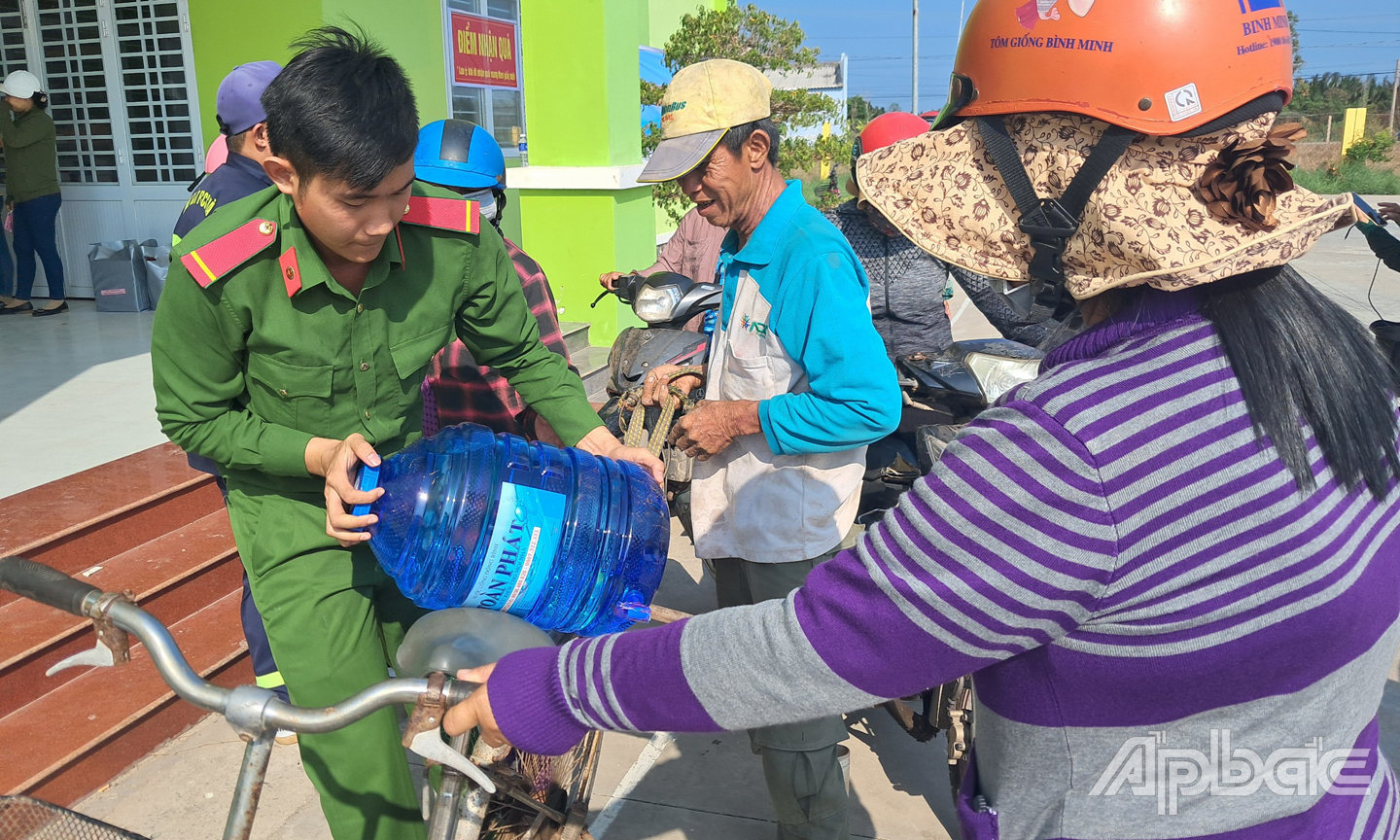 Chiến sĩ Công an tỉnh Tiền Giang hỗ trợ ngươi dân chở nước về nhà.