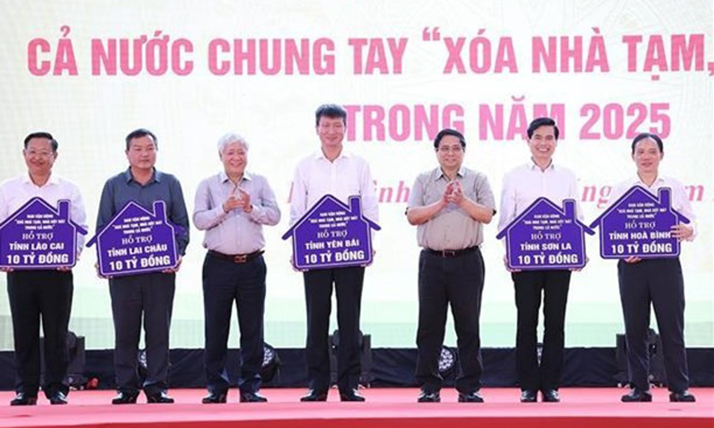 From right: Prime Minister Pham Minh Chinh (3rd) and Chairman of the Vietnam Fatherland Front Central Committee Do Van Chien (5th) hand over the tokens of funds allocated to assist in the removal of temporary and ramshackle houses across several provinces. (Photo: VNA)