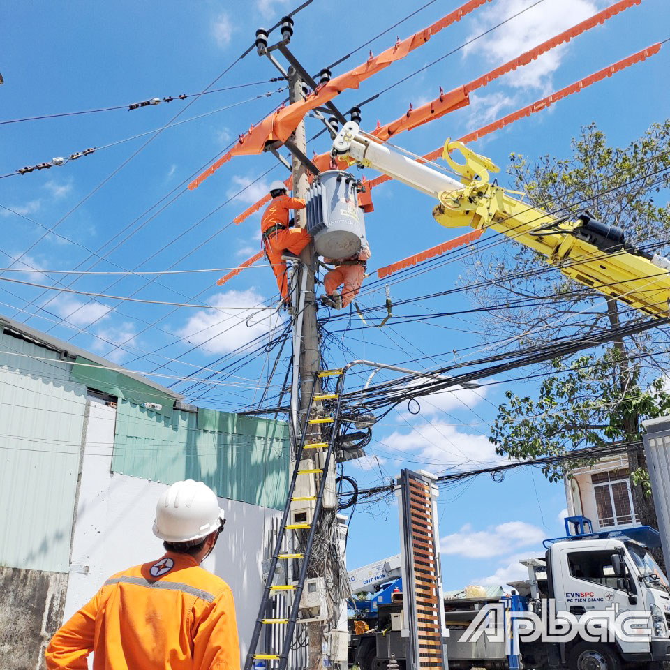 Công nhân Công ty Điện lực Tiền Giang thực hiện lắp đặt trạm biến áp chống quá tải bằng Hotline.