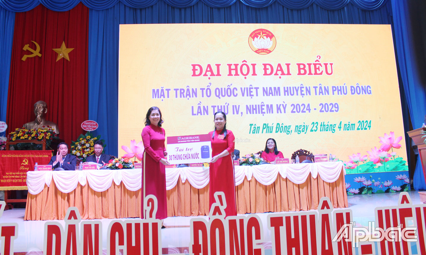 Bà Nguyễn Ngọc Oanh, Phó Giám đốc Agribank Tiền Giang trao biển tượng trưng 30 thùng chứa nước cho đại diện Ủy ban MTTQ huyện Tân Phú Đông 