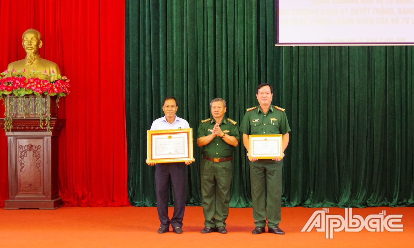 Đại tá Bùi Văn Vũ, Chính ủy BĐBP Tiền Giang trao Huân chương bảo vệ Tổ quốc và Bằng khen của Bộ Quốc phòng cho 2 cá nhân.