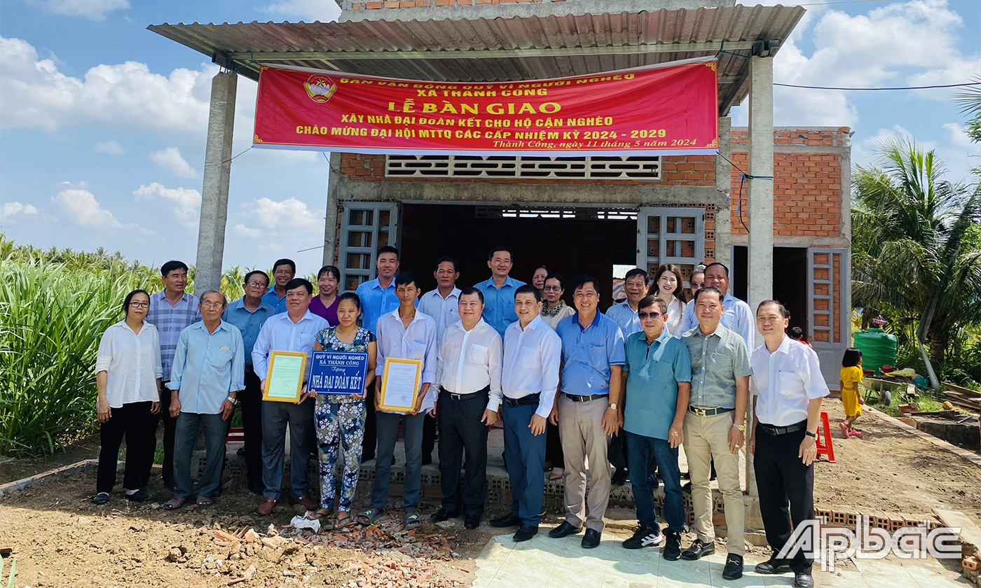 Đại biểu cùng chính quyền địa phương chụp ảnh lưu niệm với gia đình a Giang bên ngôi nhà mới