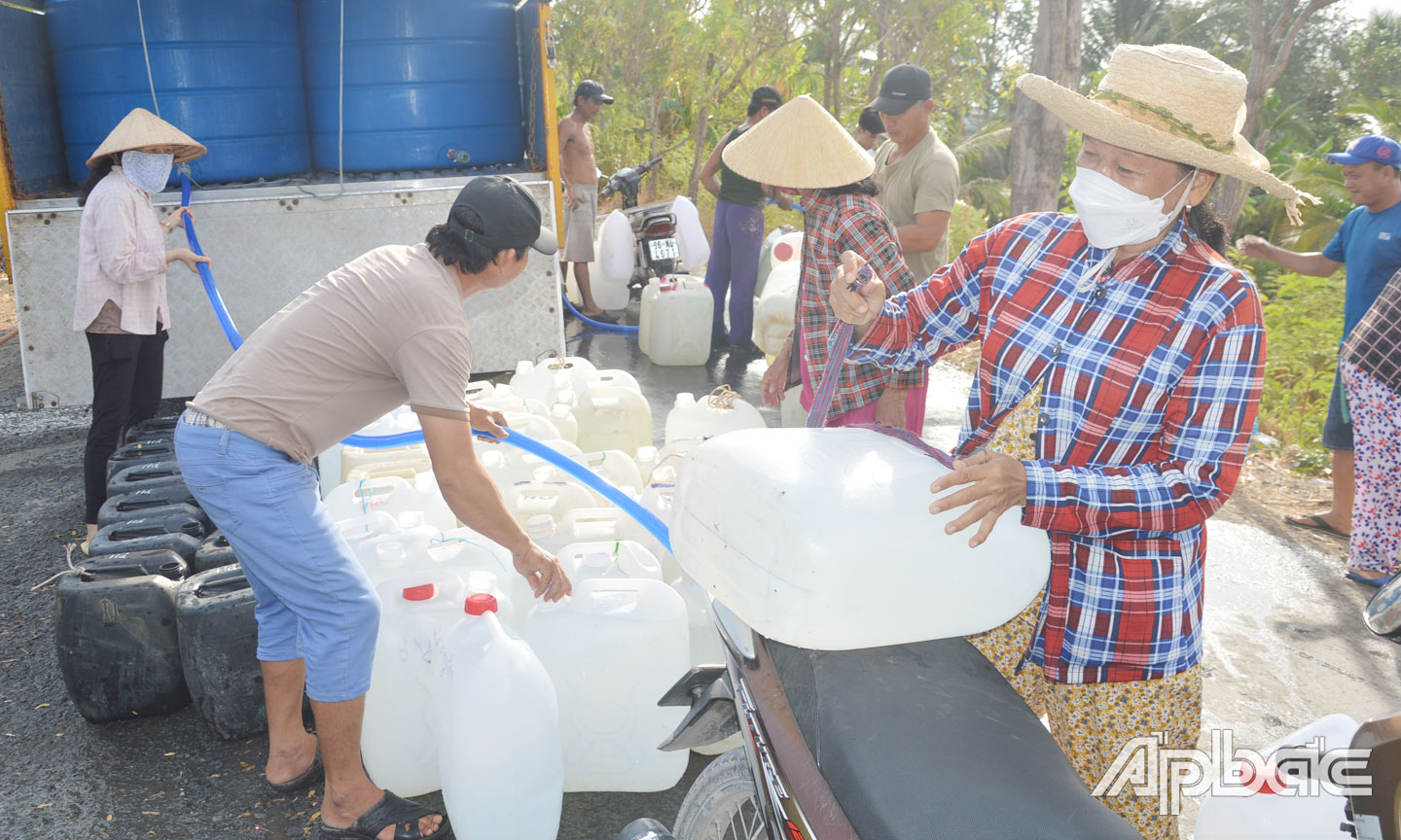 Chị Linh và nhiều người dân đến chở nước từ các xe nước từ thiện về sử dụng.