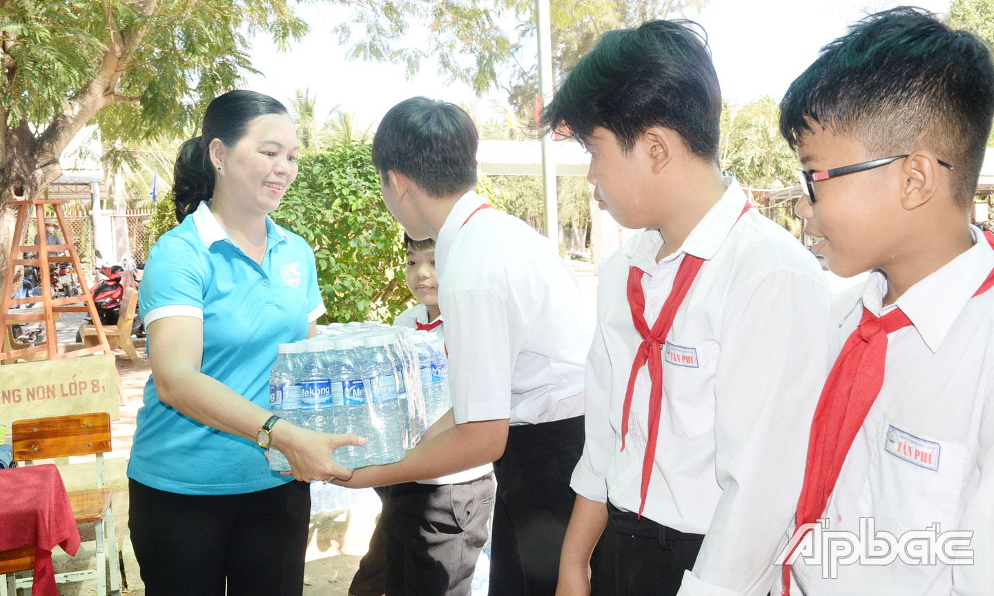 Chủ tịch Hội LHPN tỉnh Nguyễn Thị Kim Phượng trao nước uống cho học sinh vùng hạn mặn.
