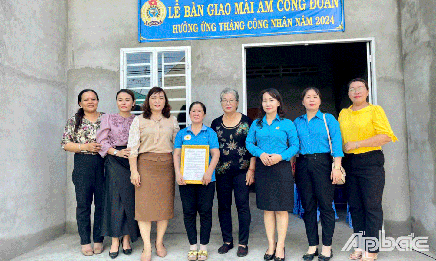 Gia đình chị Nguyễn Thị Thanh Thủy cùng đại biểu chụp ảnh lưu niệm trước ngôi nhà Mái ấm Công đoàn