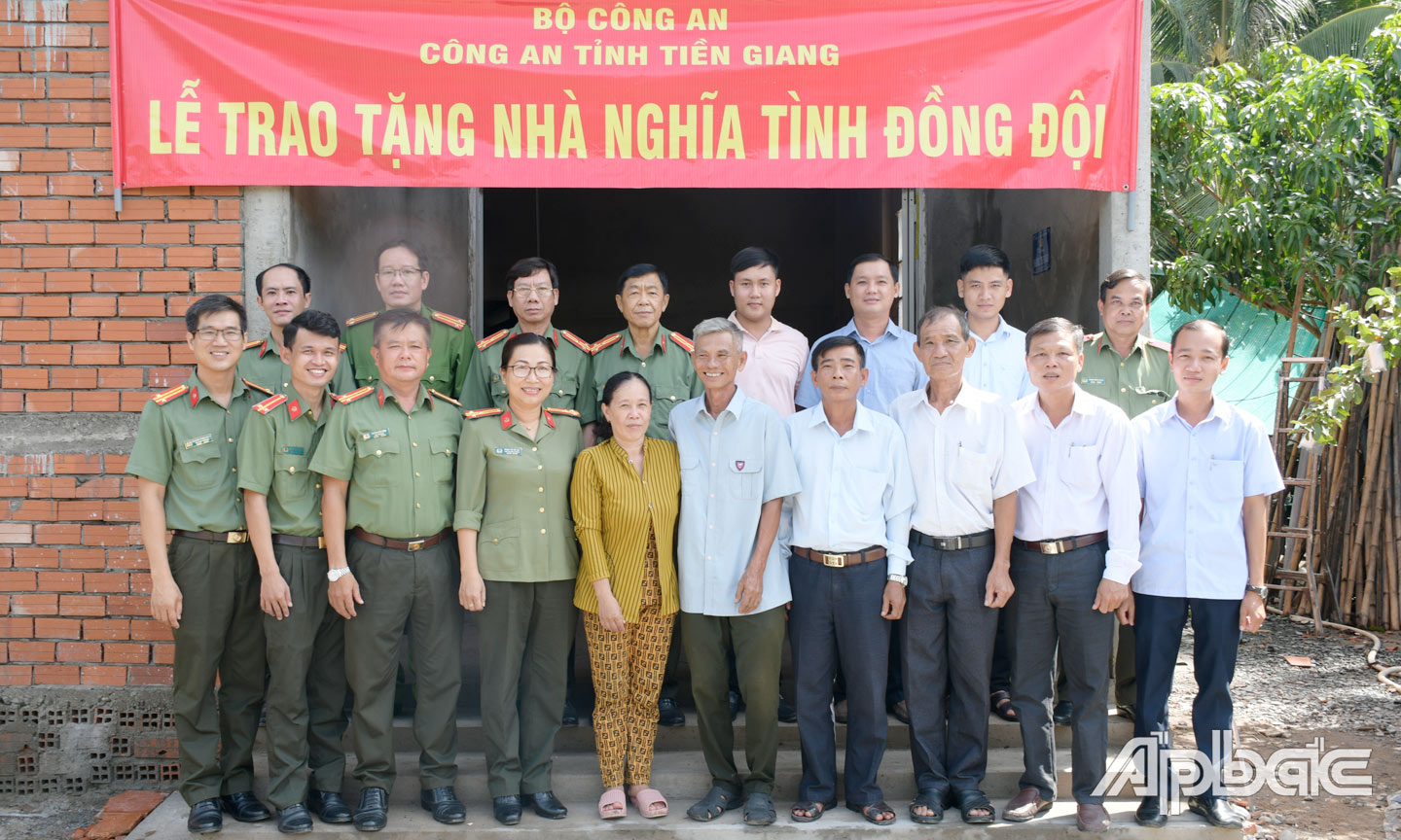 Đại biểu và gia đình Trung úy Nguyễn Ngọc Mới chụp ảnh lưu niệm bên căn nhà mới.