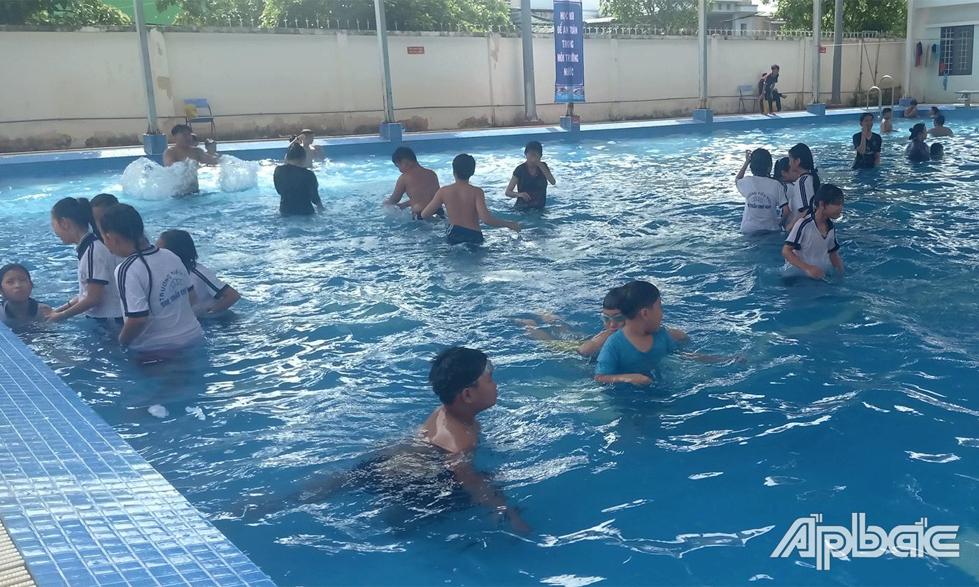 Các em tham gia bơi tại hồ bơi công viên huyện.