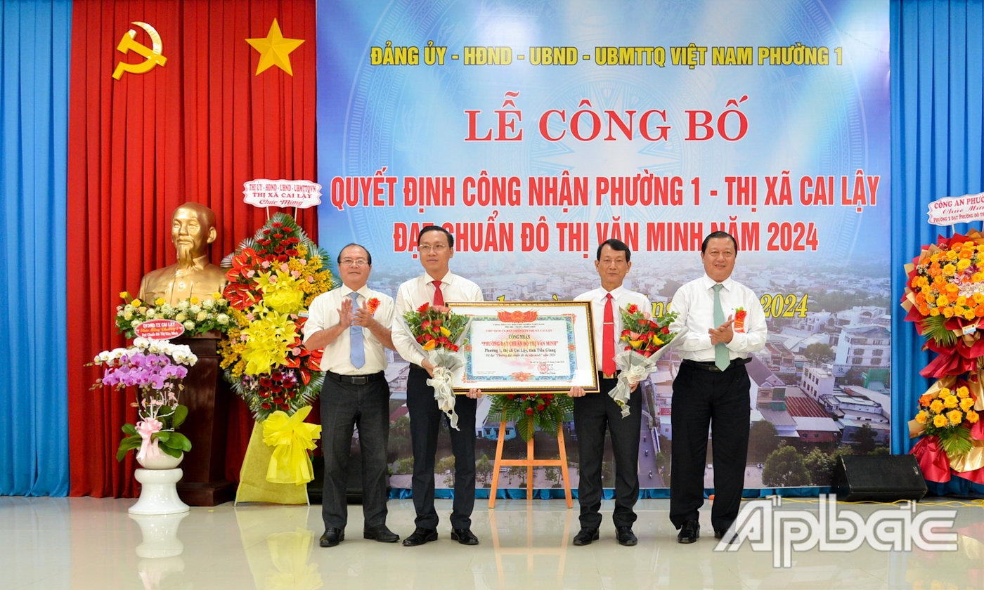 Đồng chí Phan Phùng Phú và đồng chí Trần Văn Thức trao Quyết định công nhận “Phường đạt chuẩn đô thị văn minh” và tặng hoa chúc mừng phường 1.