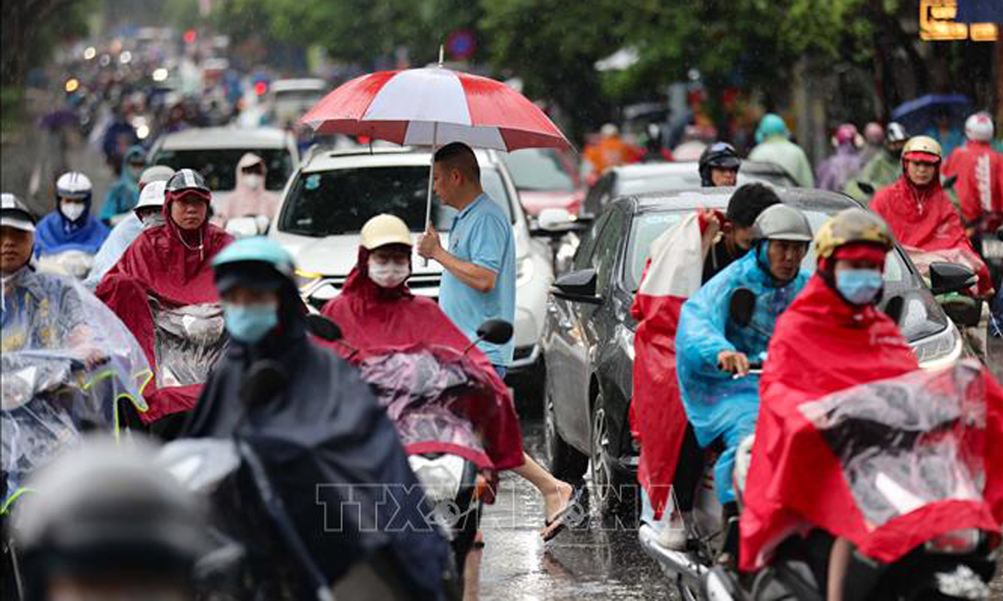 Người dân di chuyển khó khăn trên tuyến phố Minh Khai giao với Tam Trinh và Kim Ngưu, quận Hai Bà Trưng (Hà Nội), sáng 24/6. Ảnh: Thanh Tùng/TTXVN