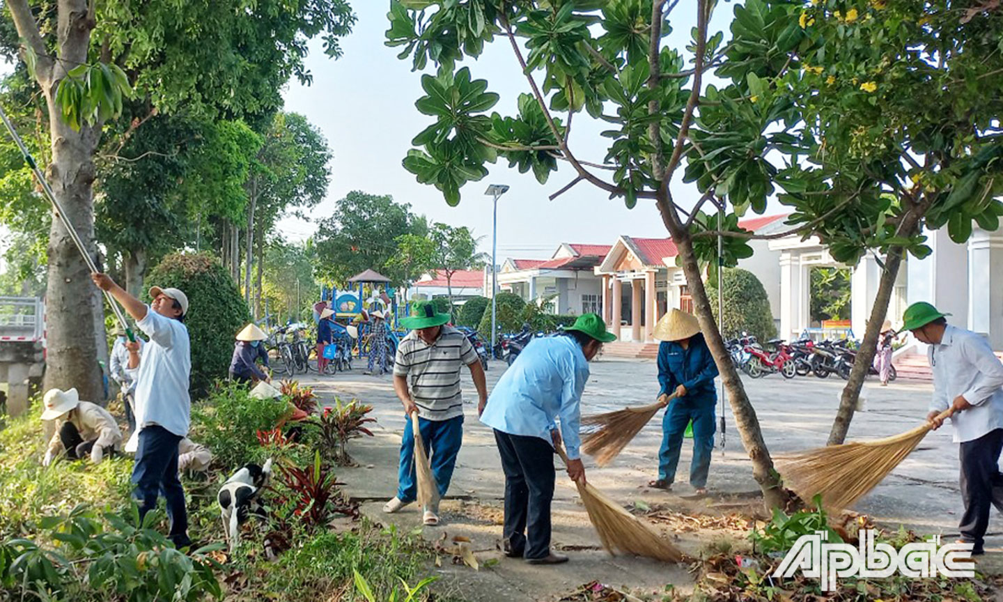 Nhân dân và học sinh trong ấp ra quân vệ sinh môi trường.