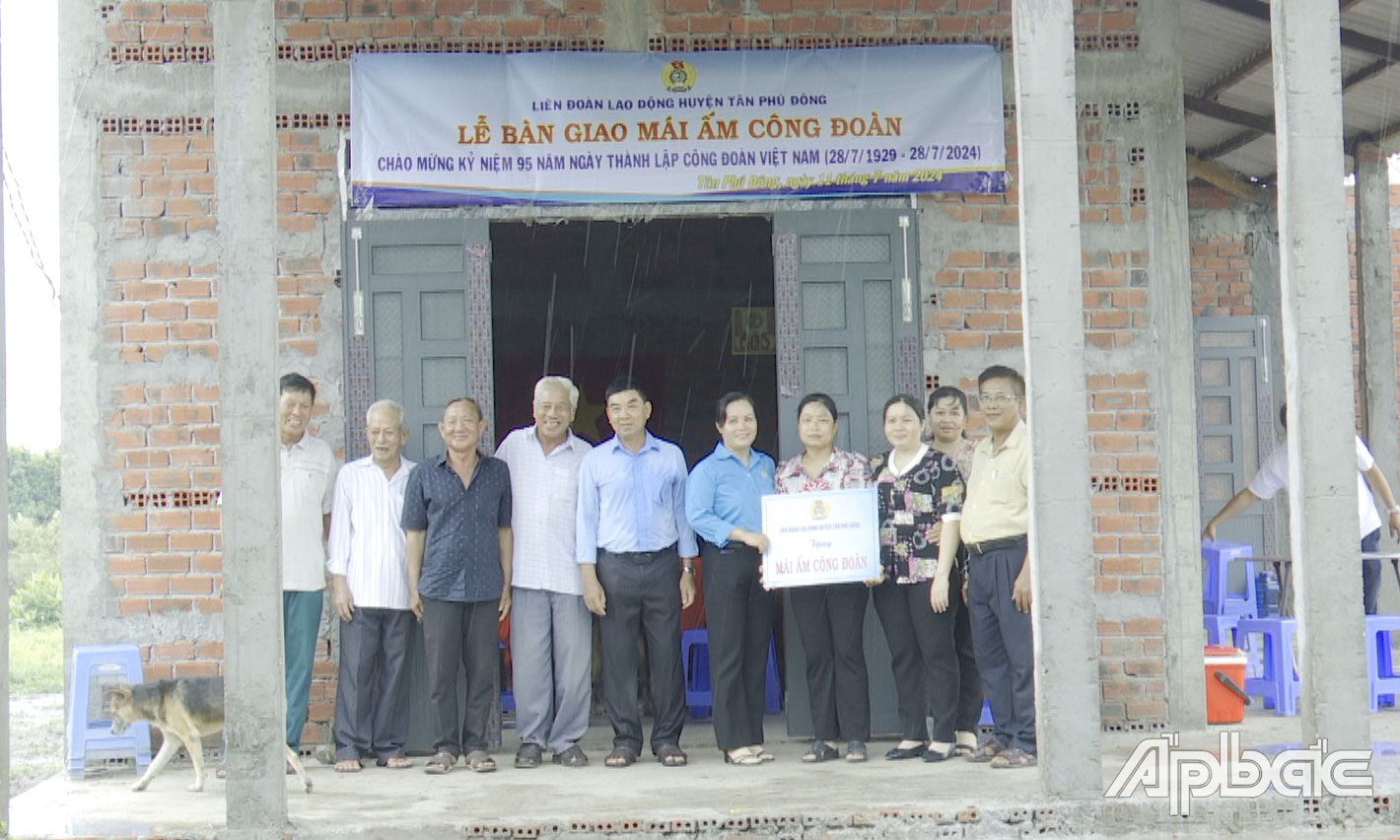 Phó Chủ tịch Liên đoàn Lao động huyện Tân Phú Đông Huỳnh Thị Thu Hồng trao quyết định bàn giao nhà cho công đoàn viên.