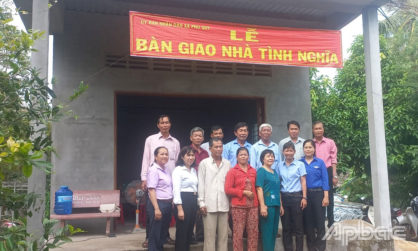 Nhà tài trợ, chính quyền địa phương và người thân ông Lễ chụp ảnh lưu niệm trước căn nhà mới.