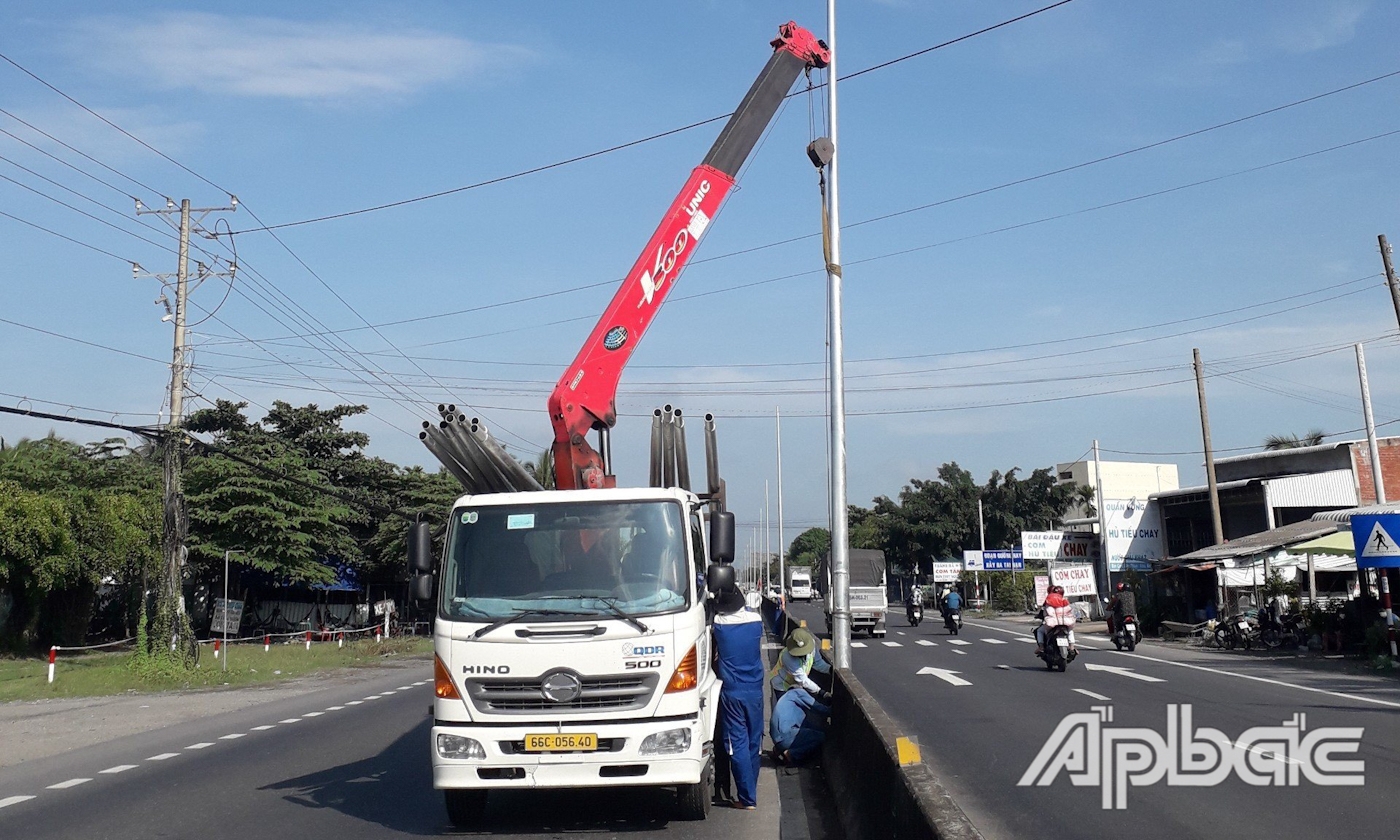 Thi công lắp đặt hệ thống chiếu sáng trên tuyến Quốc lộ 1, đoạn qua địa bàn huyện Cai Lậy.