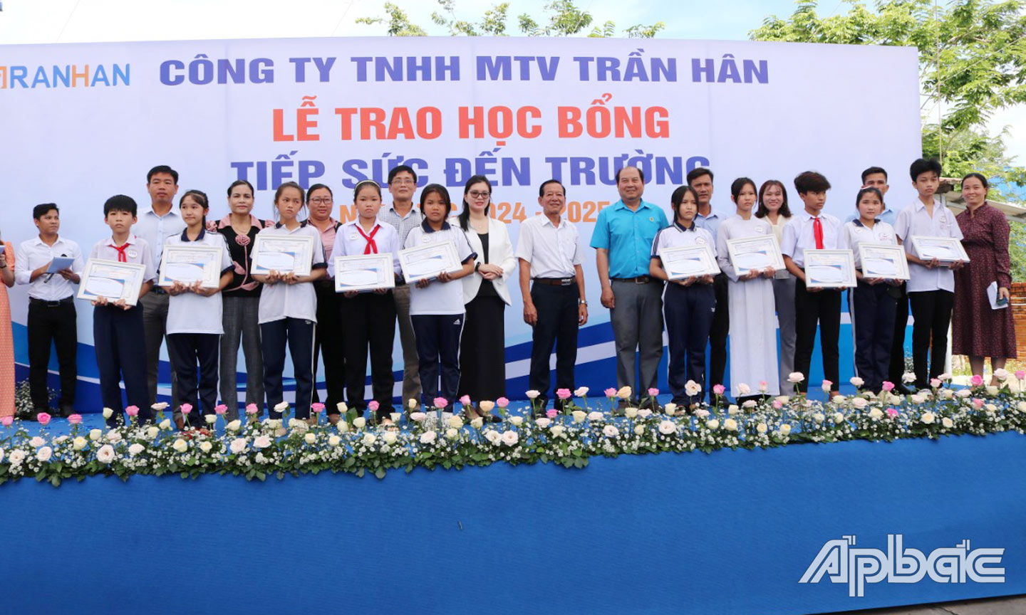 Lãnh đạo huyện, xã và công ty trao học bổng cho học sinh. 