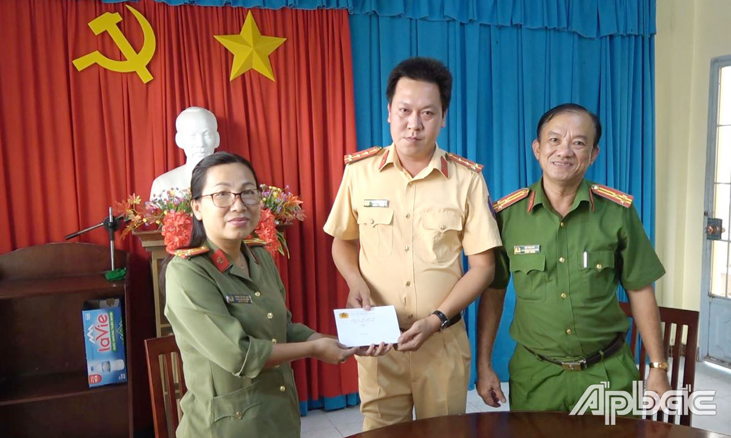 Đồng chí Thượng tá Phan Thị Hà An, Phó Trưởng phòng Tổ chức cán bộ trao quà của Ban Giám đốc Công an tỉnh tặng đồng chí Phạm Phi Long. 